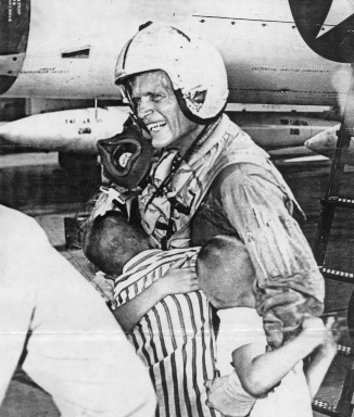 The photo shows Mark embracing his two children upon returning home from a one year tour of duty in the Mediterranean as the commanding officer of an all-weather fighter squadron of F4D Skyrays. The first supersonic jets, this plane was capable of climbing from sea level to 40,000 feet in three minutes! The squadron Mark commanded won the Marine Corps Commandant's Trophy for top combat efficiency in 1959.